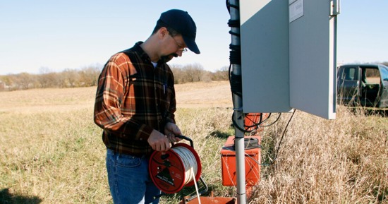 Aaron Young, a survey geologist with the Conservation and Survey Division, performs maintenance on a water well. 